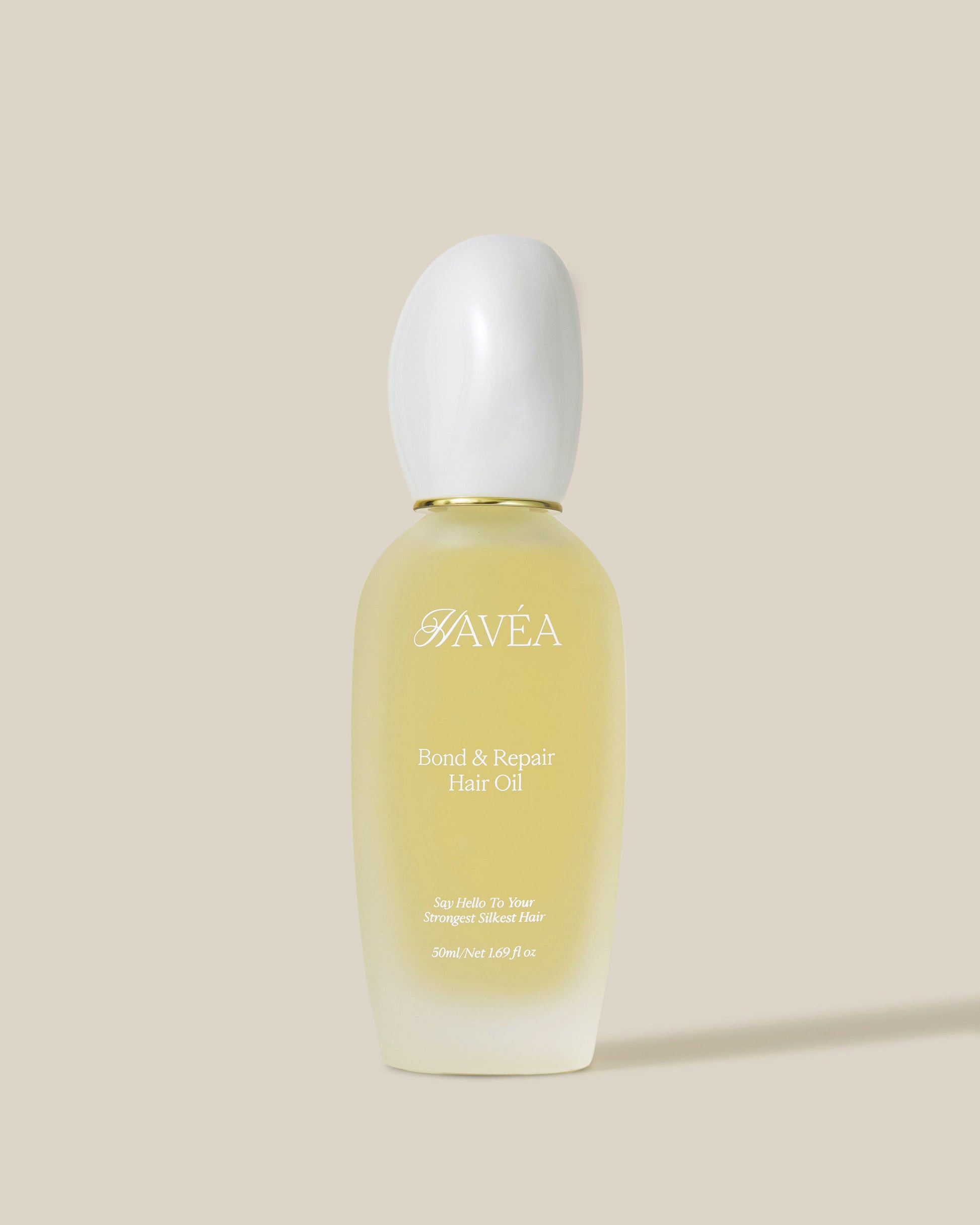 Havéa bond & repair hair oil bottle on a beige background