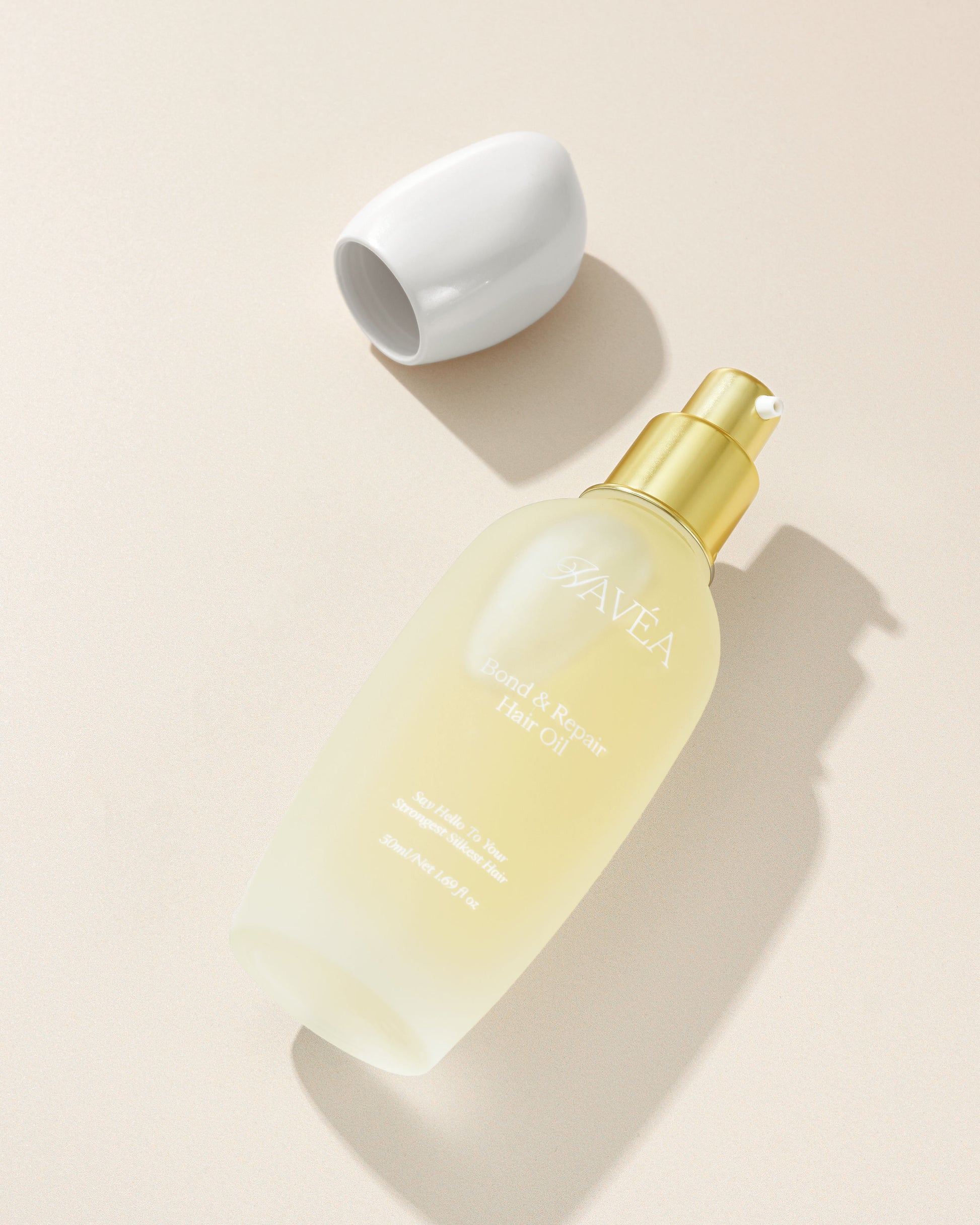 Hair care bottle with gold cap on a beige background