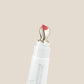 Lip applicator with pink lip color on a beige background