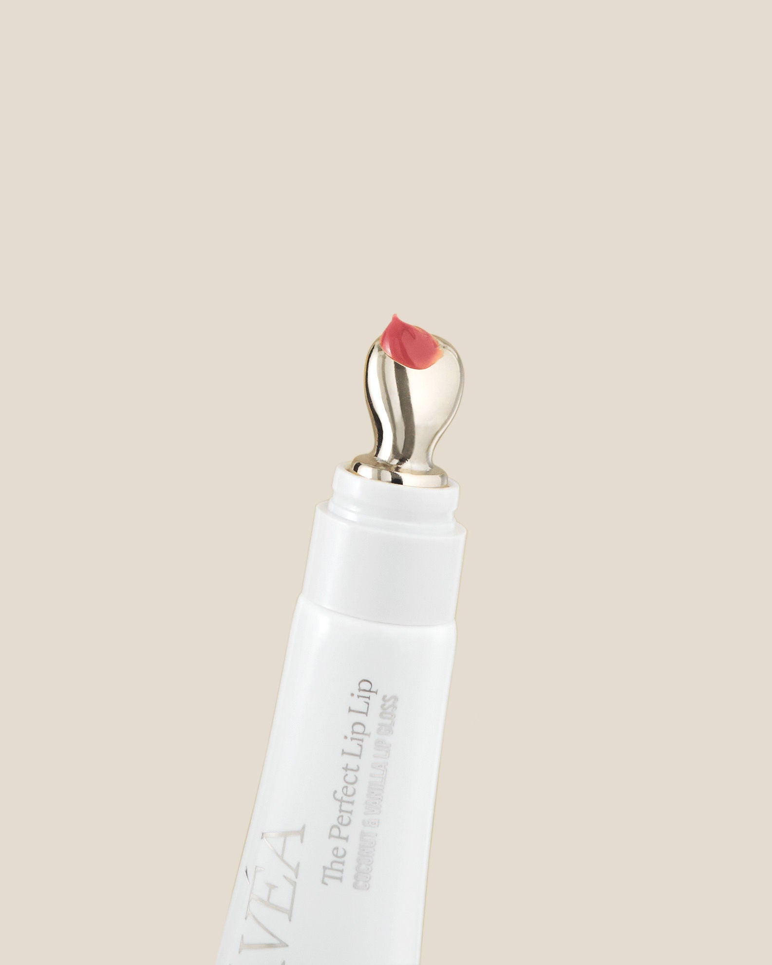 Lip applicator with pink lip color on a beige background