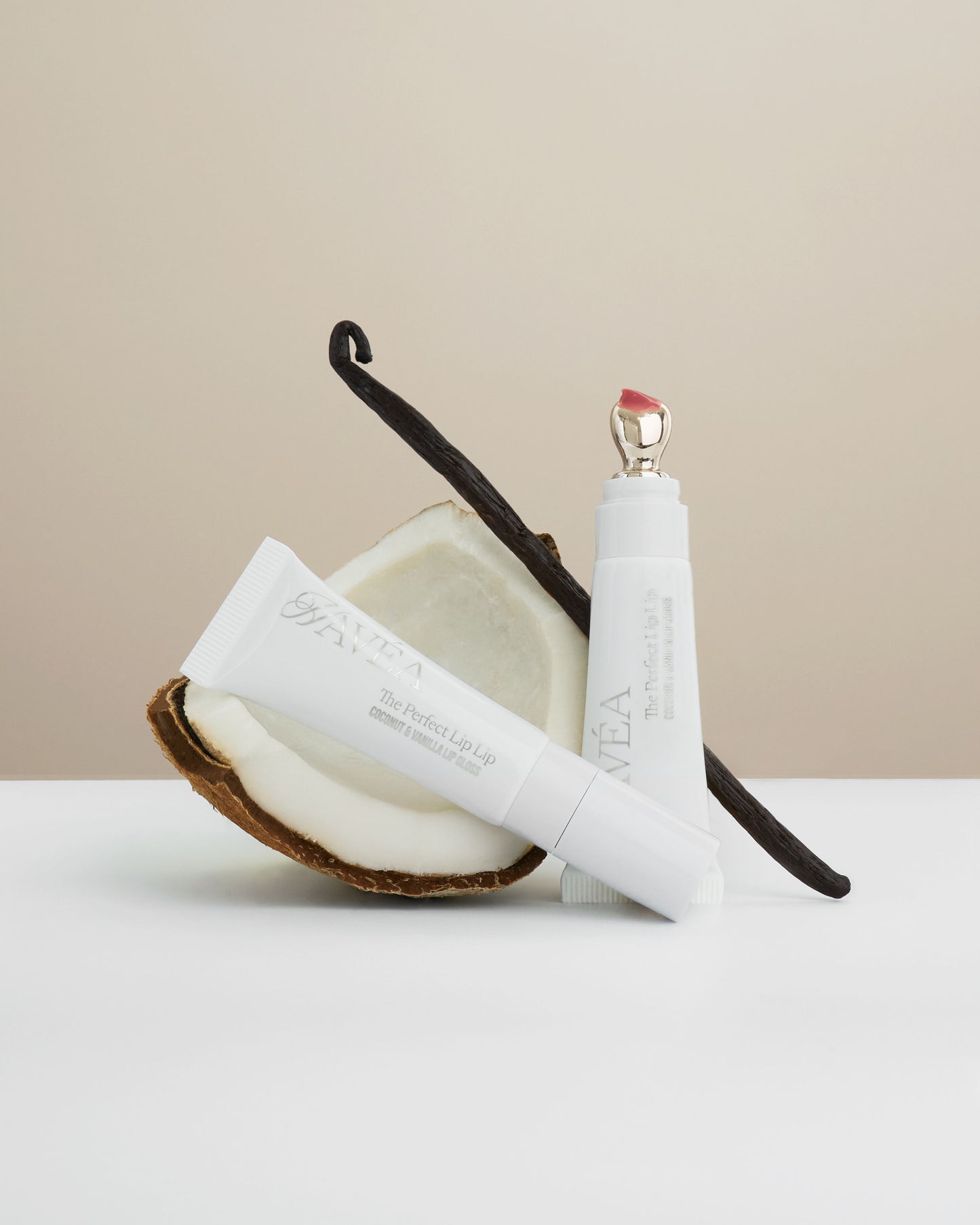 White lip care product with a vanilla bean and coconut on a beige background
